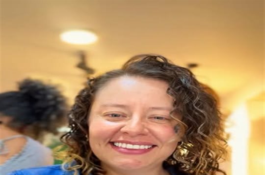 Clienta sonriente con rizos y chaqueta de jean