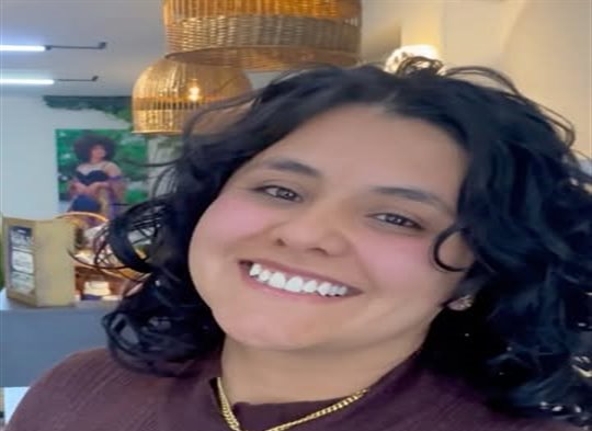 Clienta feliz con rizos oscuros recién definidos
